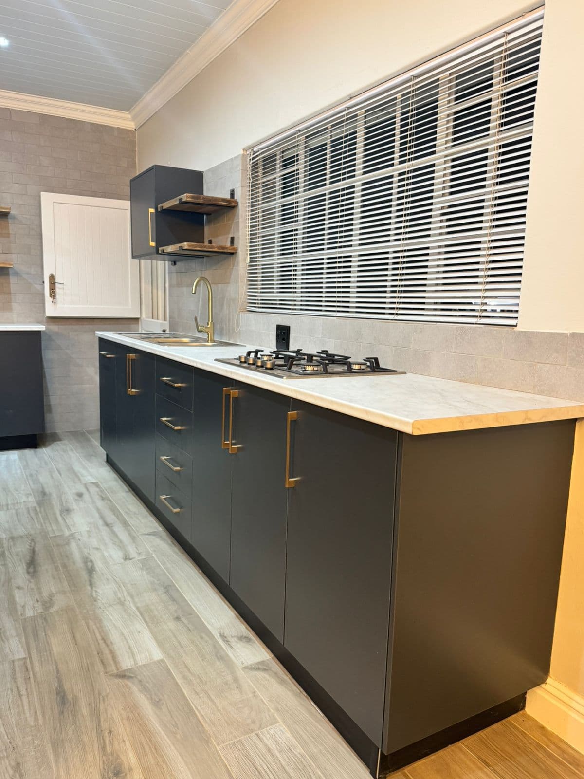 Completed Woodit kitchen in Potchefstroom with dark marble tops and modern cabinetry